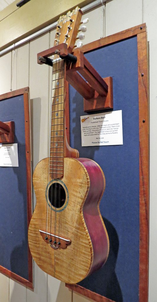 10 - Barbara Bach's purpleheart and mango tenor ukulele. Curly koa binding. Headstock is koa and quilted maple with plumeria blossoms of paua shell inlay