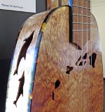 17 - Closeup of Rodney Crusat's birdseye koa pineapple tenor ukulele with dolphin and Hawaiian island design
