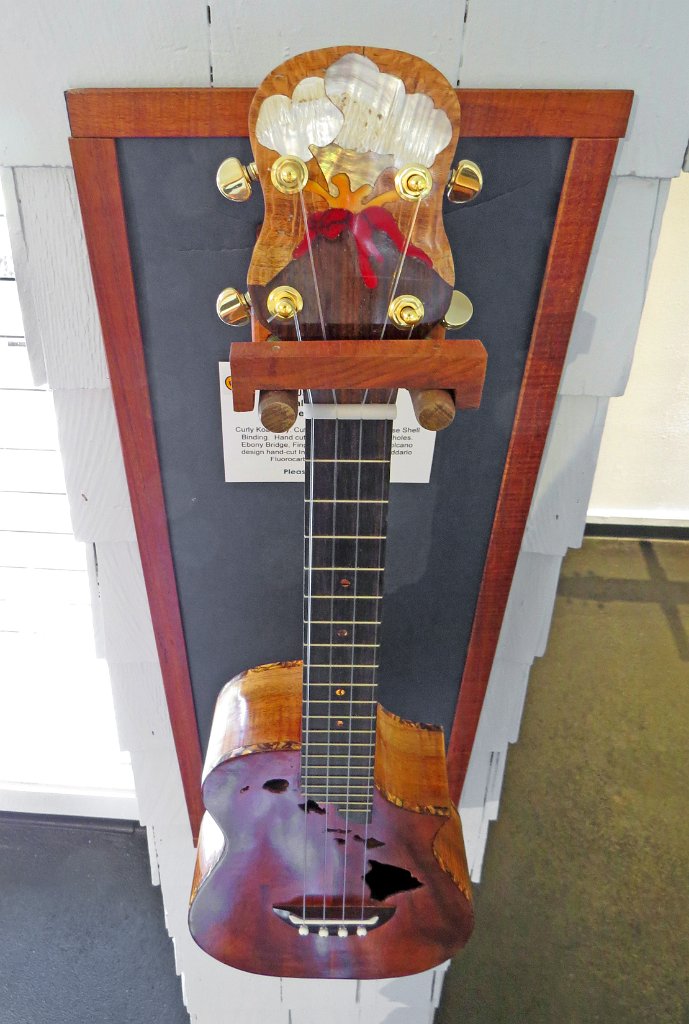 21 Jane Klassen's curly koa cutaway tenor ukulele with volcano theme headstock and Hawaiian islands soundholes 