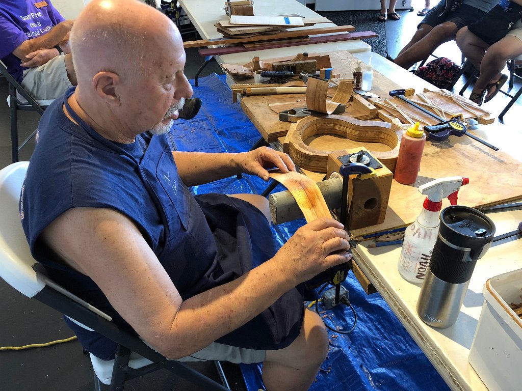 02 Sam Rosen shapes the side of an ukulele with an electric bending iron during the Saturday building demonstration