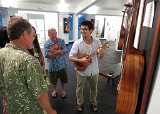 2014 Big Island Ukulele Guild exhibit 05  BIUG member Woodley White (left) offers a visitor the rare treat of playing one of his ukes during the 2014 BIUG exhibit at Wailoa Center in Hilo
