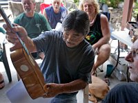 Rodney Cruzat examines an ukulele built of ‘ulu wood by Bob Gleason