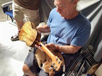 05 - Chuck Bennett checks out an ukulele along with Taco, his ever vigilant dog