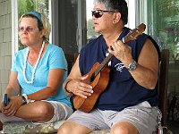 Jane Klassen listens as Tad Humble tries out a new koa uke built by Marcus Castaing