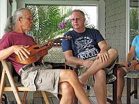 Marcus Castaing offers details about his ukulele to Tom Russell and Jane Klassen