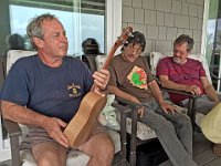 Terry Davis holds Jane Klassen's Macadamia Nut wood uke as Rodney Crusat and Woodley White wait their turn