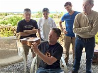 06 - Members gather around as Dave Stokes describes using a router table to remove the cedar top on a damaged ukulele